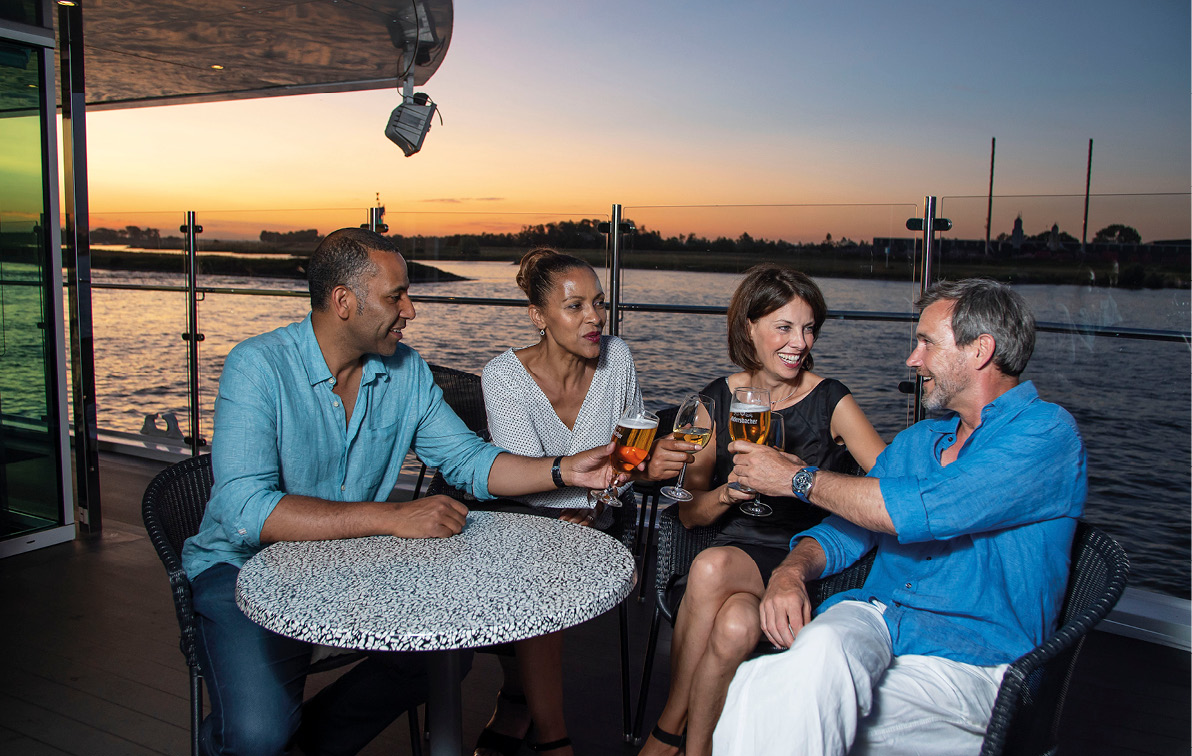 Friends enjoying an al fresco drink together on board a luxury river ship in Europe