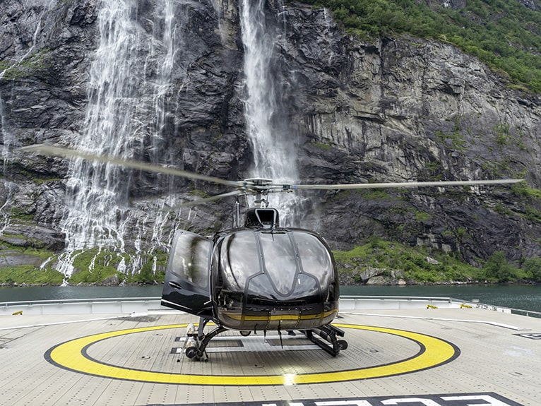Scenic Eclipse Helicopter in front of a waterfall