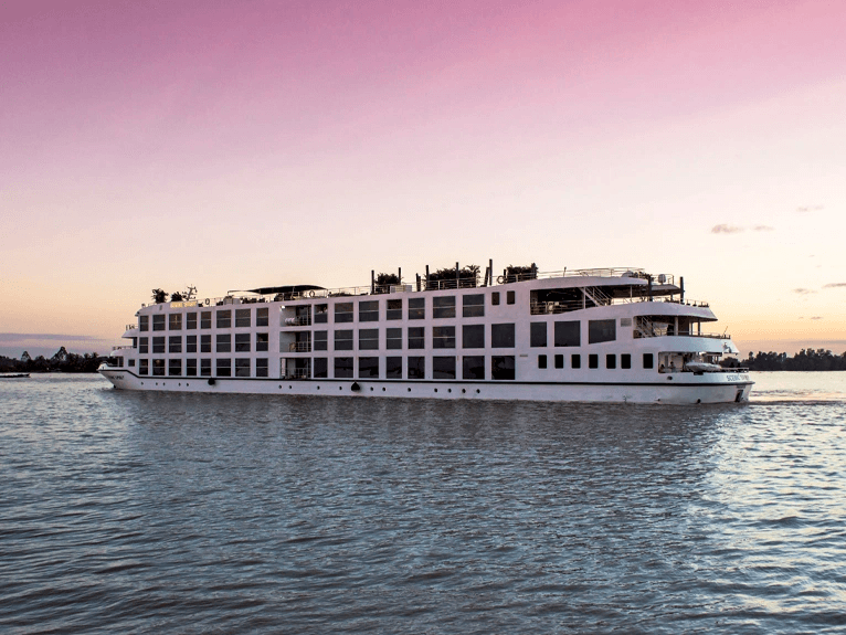 Scenic Spirit ship on the Mekong River with a pink sky above