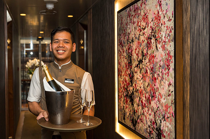 Butler holding a bottle of Champagne on a tray