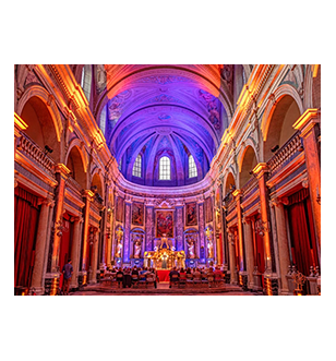 Guests watching a performance, surrounded by the stunning baroque interior of the Trinity Chapel in Lyon.