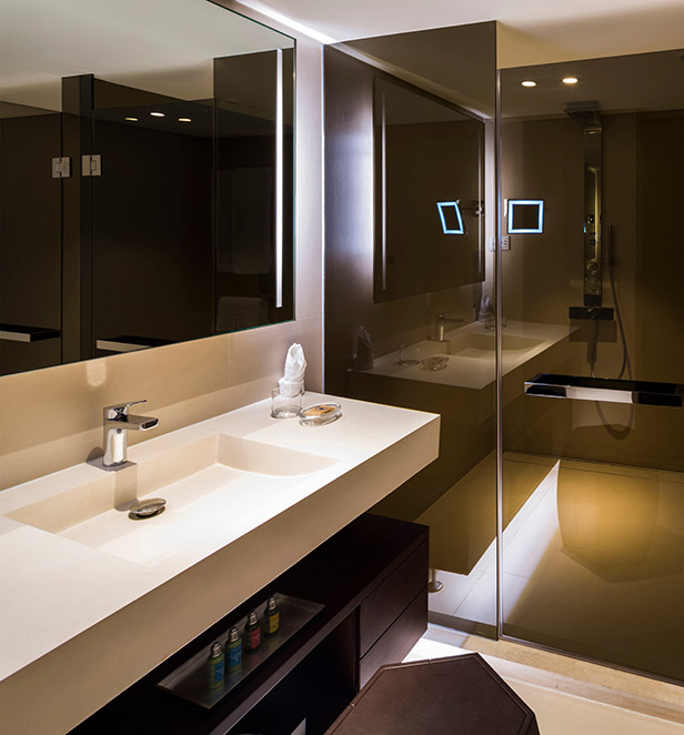 A modern and elegant bathroom in the Grand Deluxe Suite on the Scenic Spirit ship, with a spacious shower and a vanity area.
