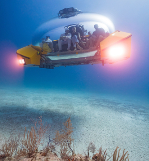 An underwater submersible, occupied by guests, is seen floating amidst the vast expanse of the ocean.